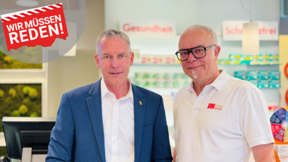 Roter, abgerissener Zettel mit weißer Schrift "Wir müssen reden" auf hellgrauem, runden Hintergrund. Zwei Männer, graue Haare - Jürgen Haußmann links (blaues Jaket) und Stefan Noe (weißes Polohemd, schwarze Brille)